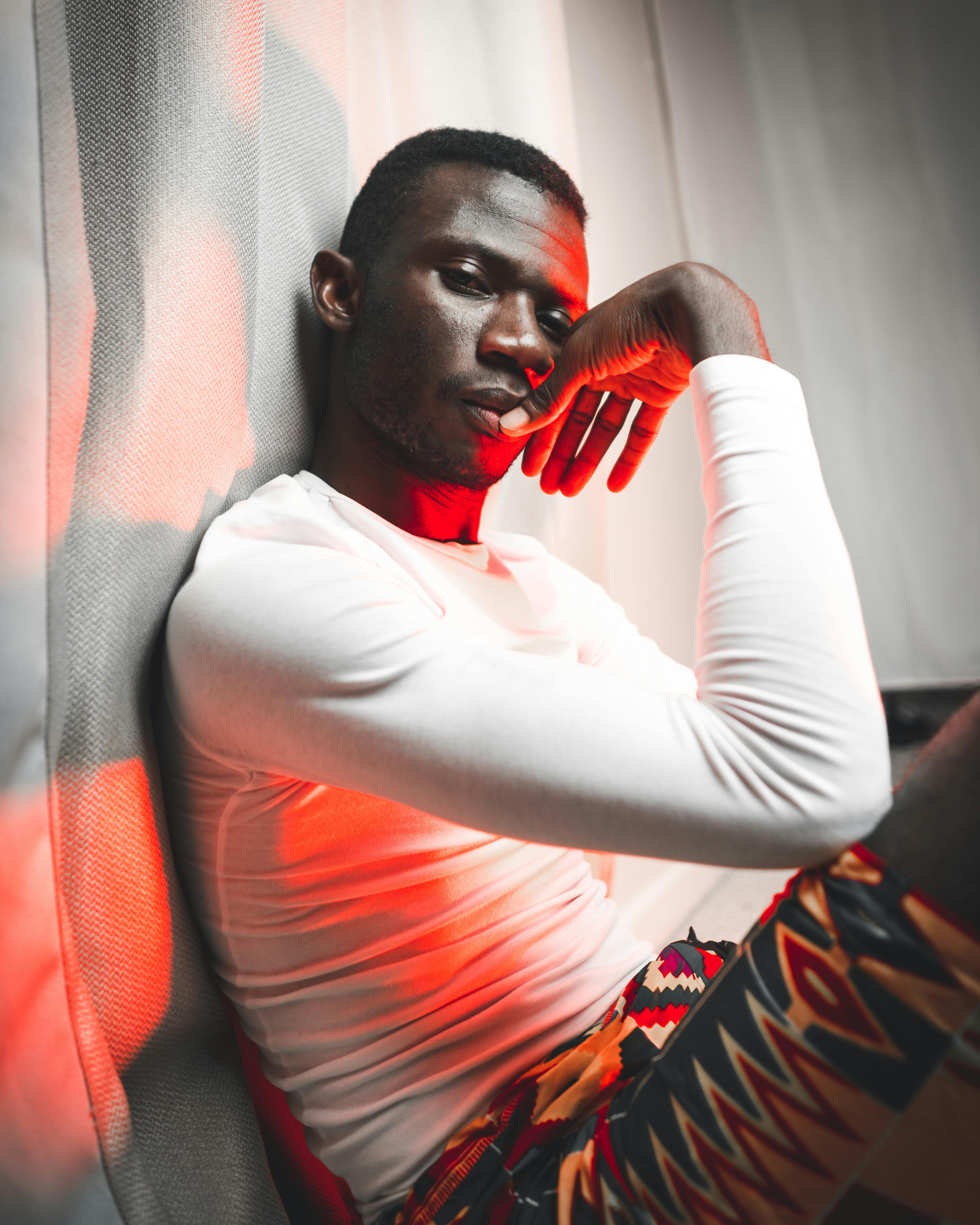 pensive african man sitting under neon illumination