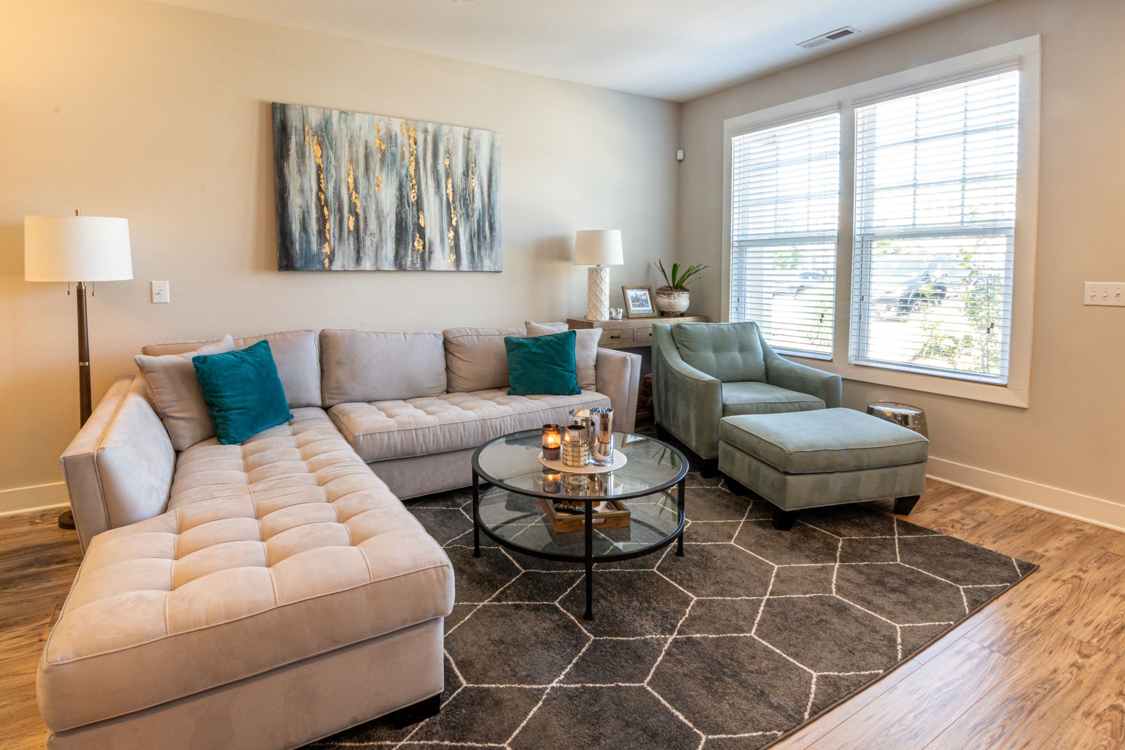 Living room with a neutral corner sofa, accent chair and large windows