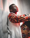 African man with frown look sitting under red light