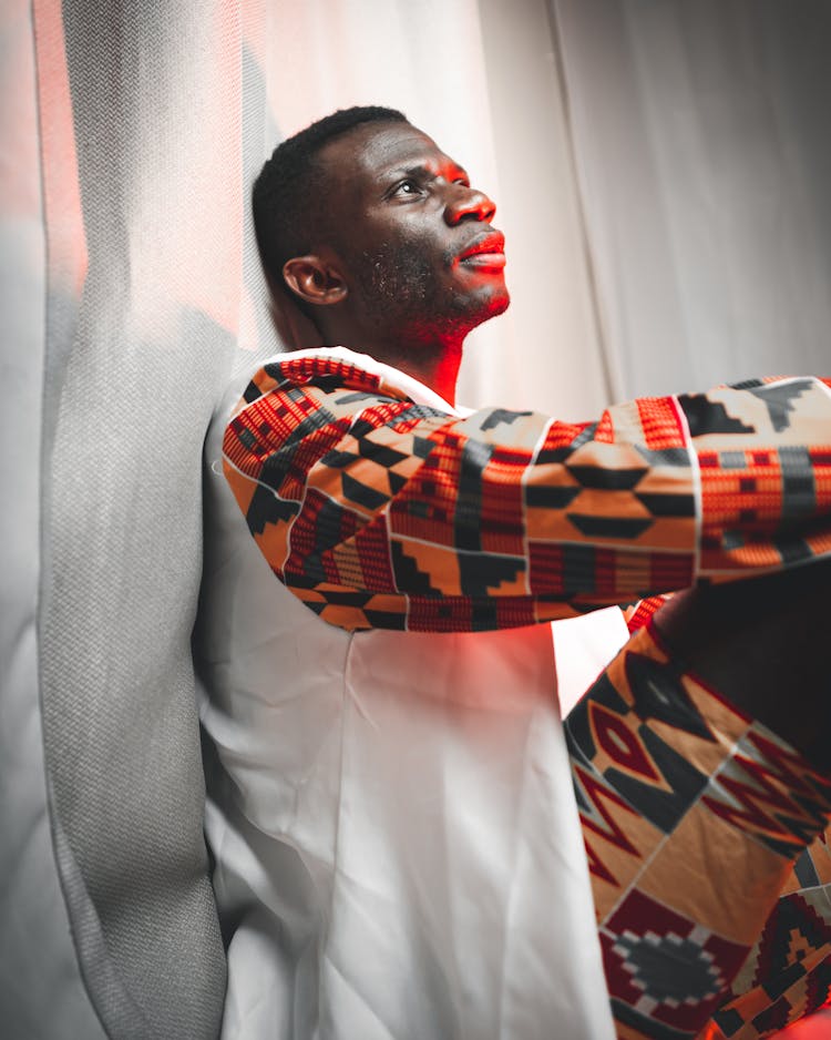 African Man With Frown Look Sitting Under Red Light