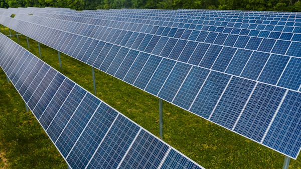 Aerial view of solar panels in a green field