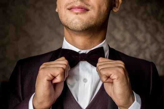 Close-up of a man adjusting a black bow tie, exuding elegance and style.