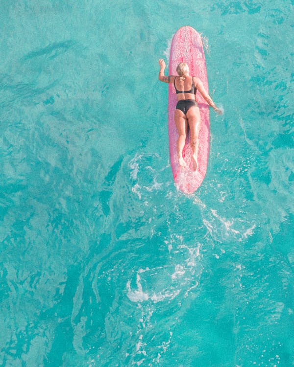 Free Woman in Pink Bikini Lying on Pink Inflatable Float on Water Stock Photo