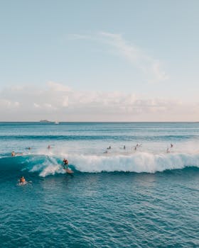 Experience the thrill of surfing in Honolulu with vibrant sunset waves and oceanic views.