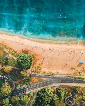 Stunning aerial view of Waikiki Beach with turquoise waters and lush greenery in Honolulu, Hawaii.