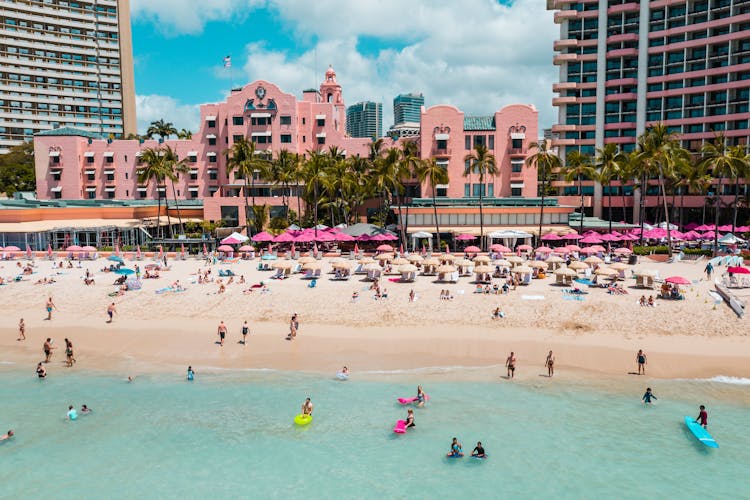 Busy Tourists Swimming On The Beach