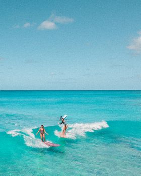 两名冲浪者在夏威夷碧绿的海水中体验着岛屿生活的刺激