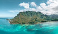 鸟瞰图令人惊叹，它展示了在充满活力的天空下，郁郁葱葱的青山与碧绿的海水