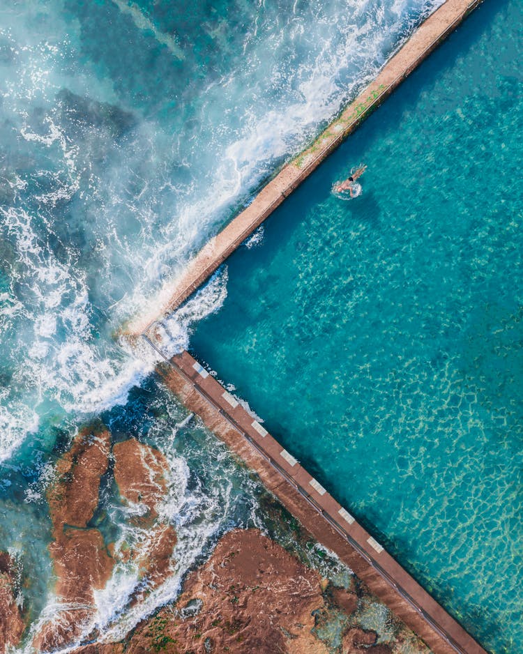 Aerial Photography Of A Person Floating On The Swimming Pool