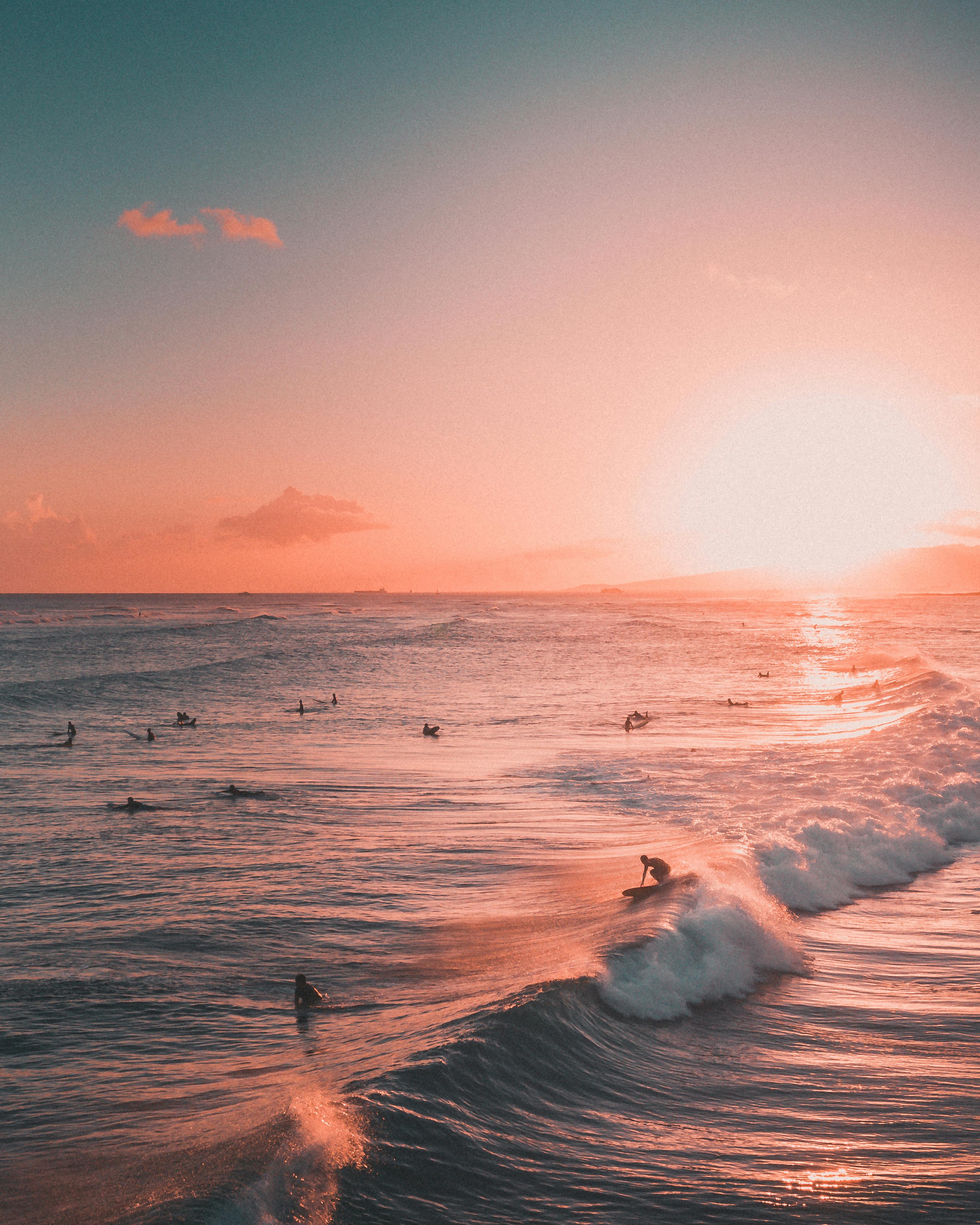 ocean waves crashing on shore during sunset