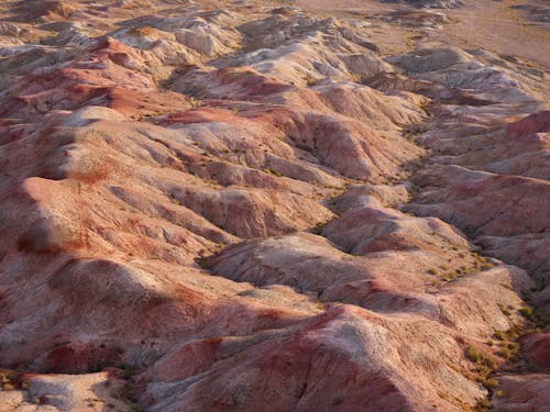 Multicolored sand dunes in desert in daylight