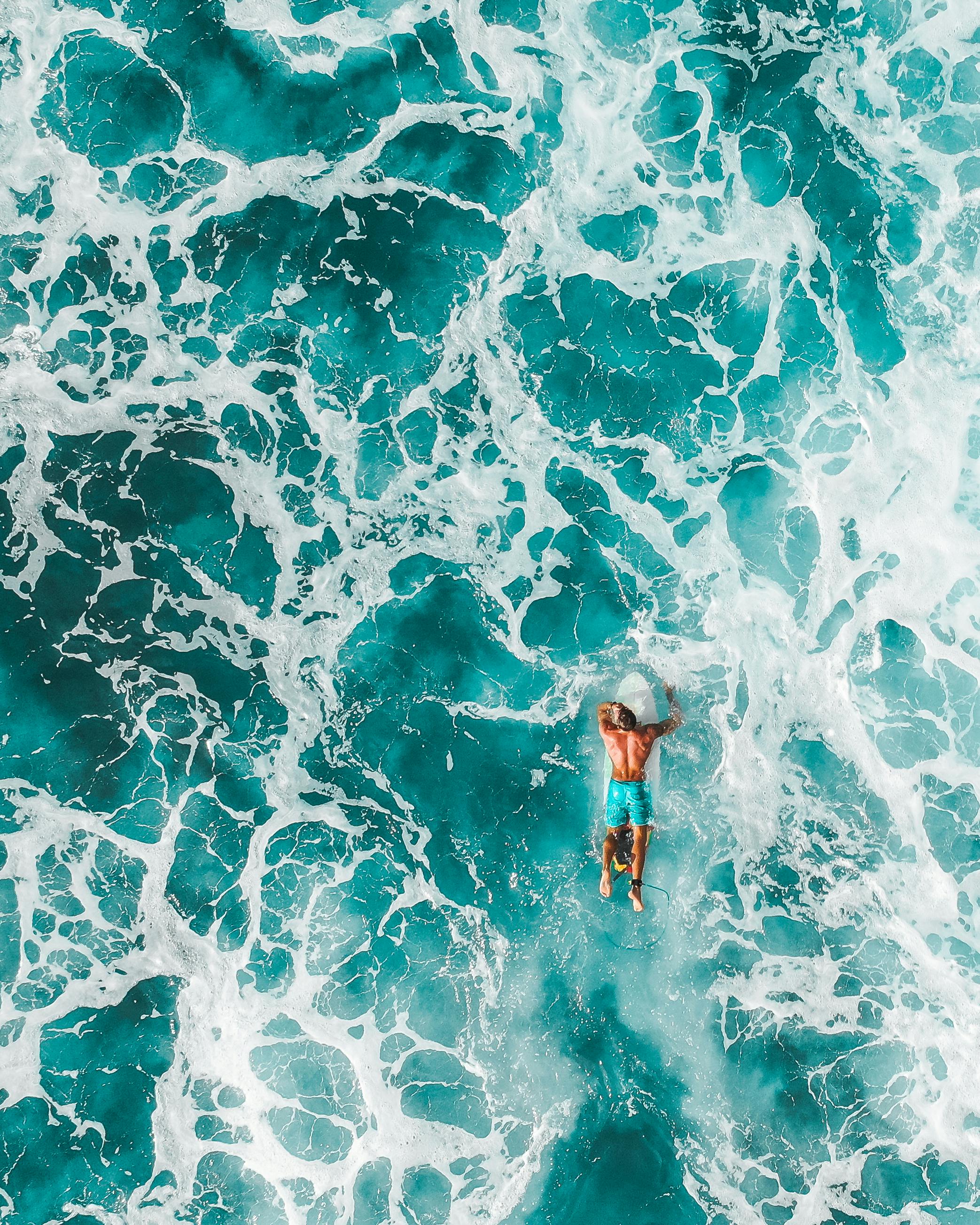 woman in blue and white bikini swimming on water