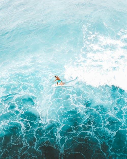 Man Surfing on Blue Sea Water