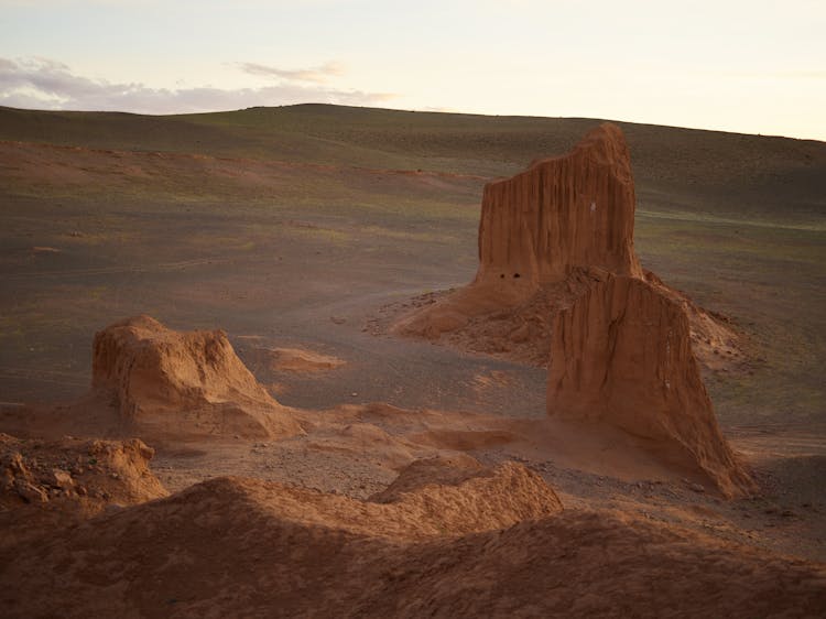 Dry Sandstone Rocks On Rough Ground Of Desert