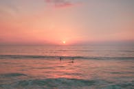 夏威夷海洋上超现实的日落，冲浪者享受着充满活力的海浪