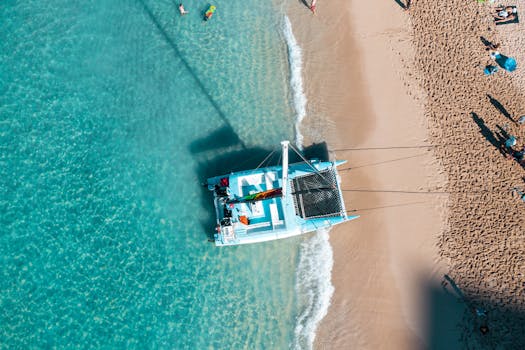Stunning aerial photo of a catamaran on Waikiki Beach, Hawaii's turquoise waters.