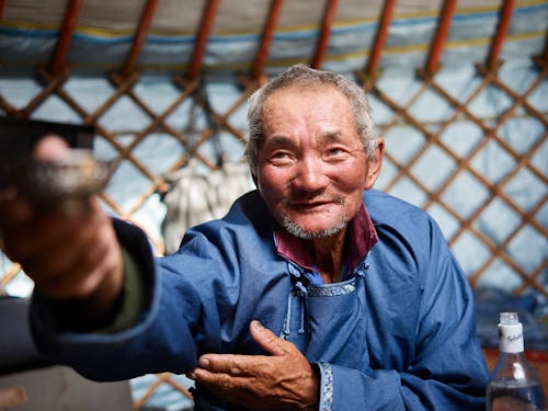 Hospitable senior Asian man in yurt