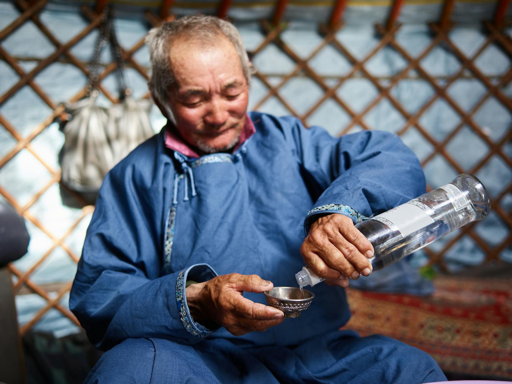 Ethnic man pouring vodka in Singing Bowl