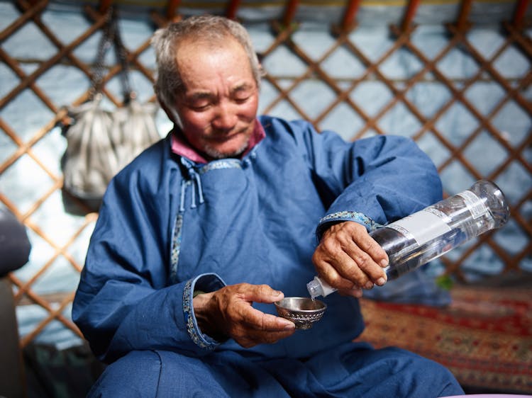 Ethnic Man Pouring Vodka In Singing Bowl