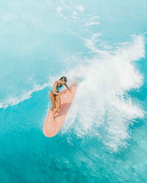 Woman in Pink Bikini Surfing on Water