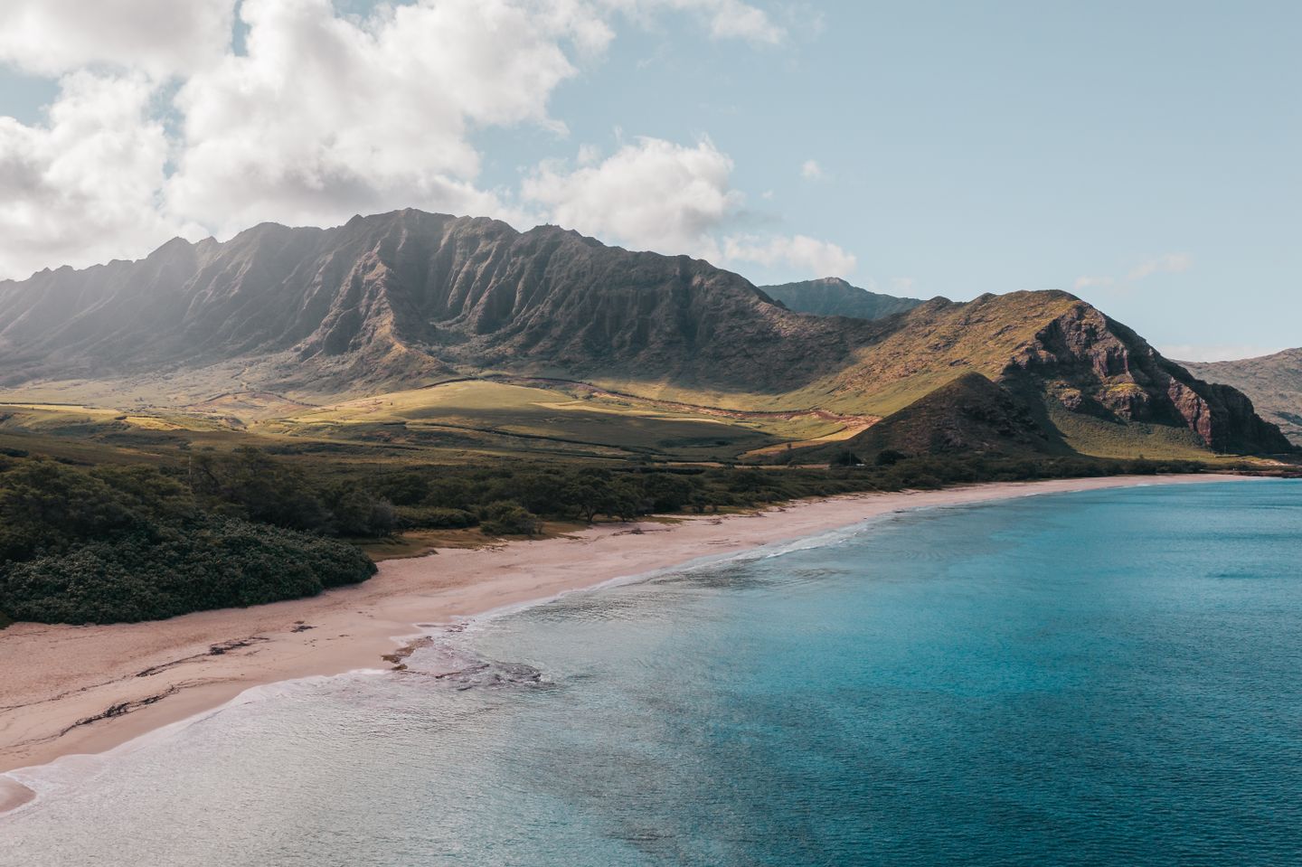 A steep Hawaiian coastline with mountains dropping to the ocean