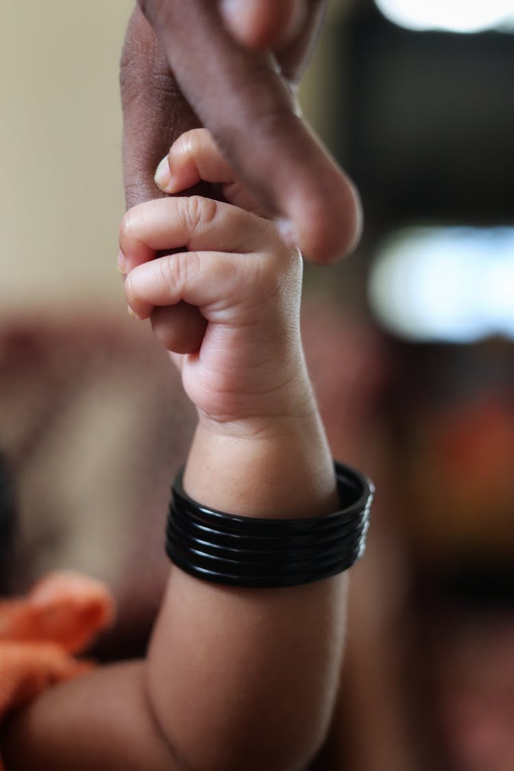 A Baby Wearing Black Bracelet