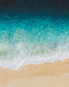 这张航拍照片令人惊叹，碧绿色的海浪拍打着沙滩，非常适合夏季主题