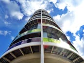 低角度视角下的现代摩天大楼，配有彩色玻璃板和明亮的蓝天