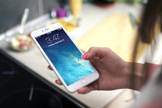 厨房里，一个人手持智能手机，屏幕上显示着锁屏界面的特写镜头