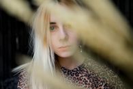 Through straw stem crop emotionless serious female wearing casual clothes in tiger print in dark room