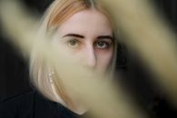 Crop pensive young woman in dark room
