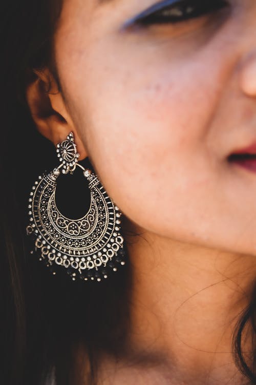 A Woman Wearing a Silver and Black Earring