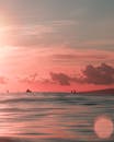 海洋上令人惊叹的柔和粉色日落，地平线上有轮廓