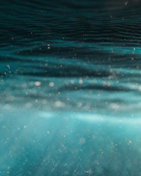 Tranquil underwater view capturing serene ripples and sunlight in azure water.