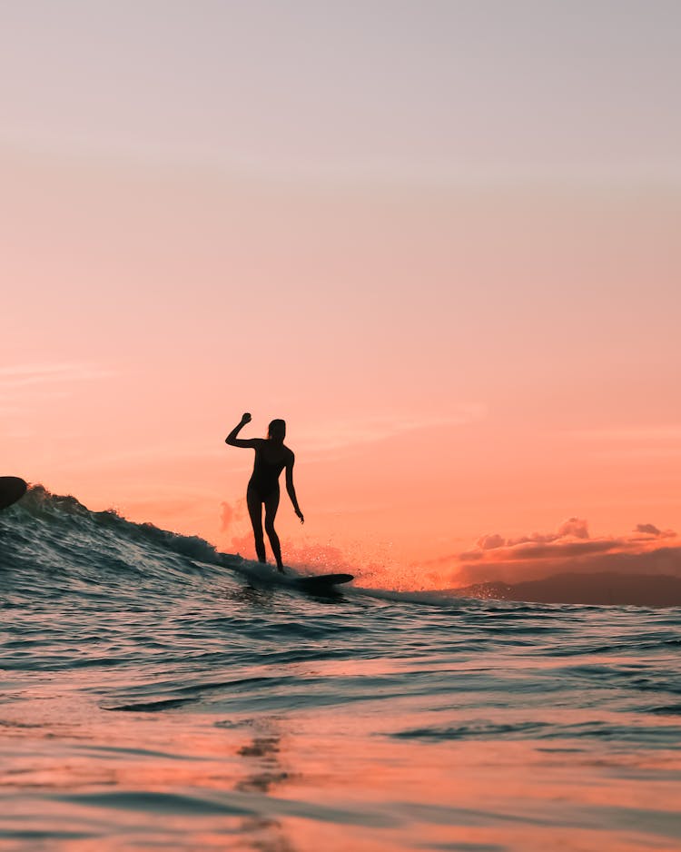 Silhouette Of A Person Surfing During Sunset