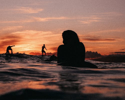 Free Silhouette of People Surfing on the Sea during Sunset Stock Photo