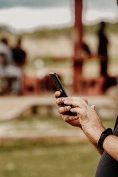 Close-up of a man using a smartphone in an outdoor setting in Tanzania, highlighting digital connectivity.