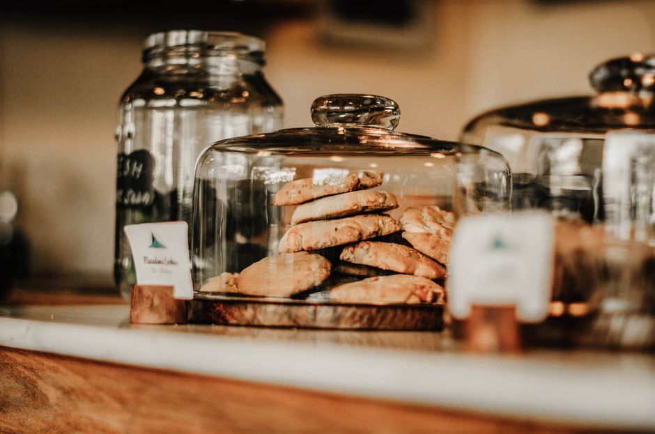 A tempting display of homemade cookies under glass dome at a cozy café in Tanzania.