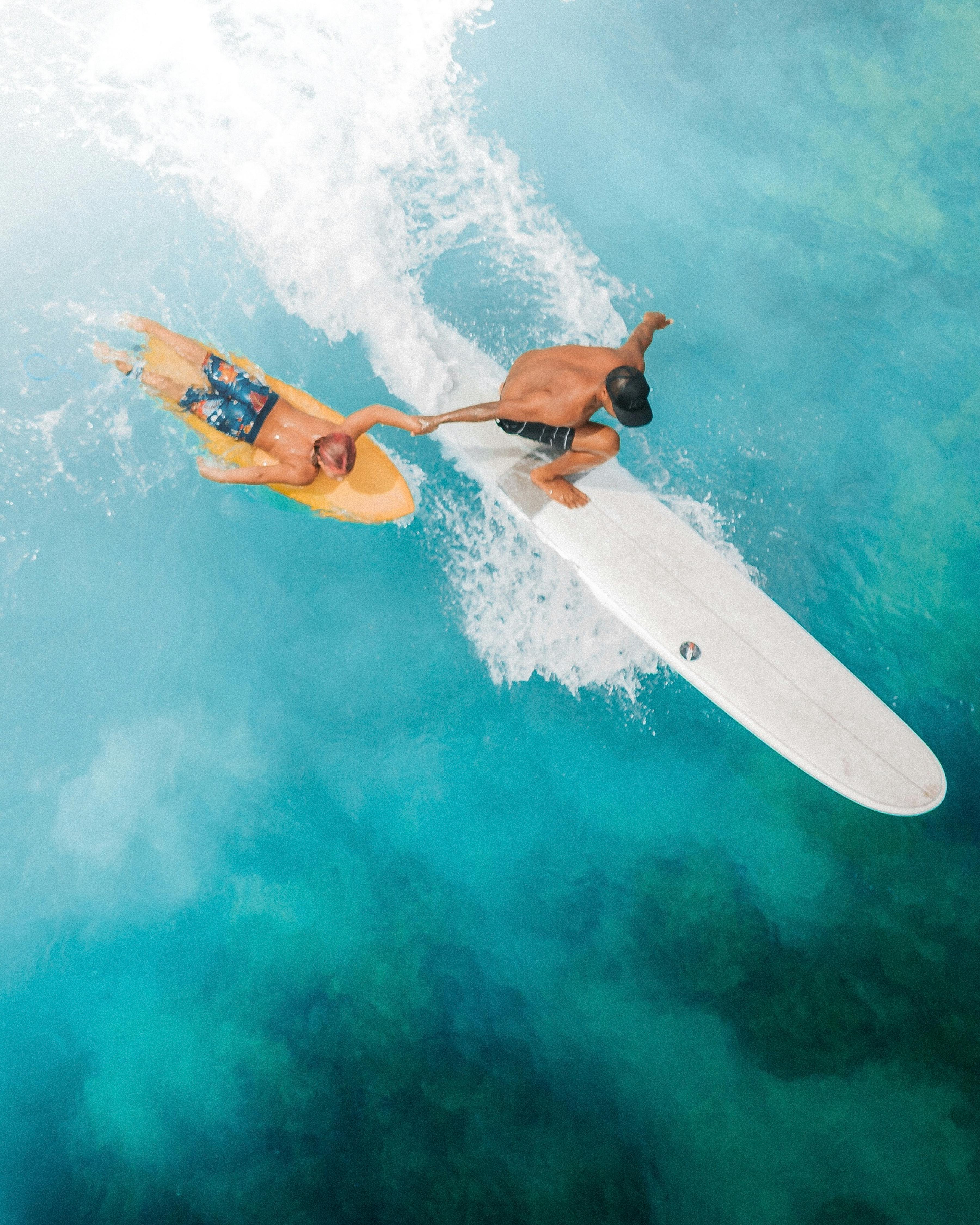 Woman in Orange Bikini Lying on White Surfboard on Water