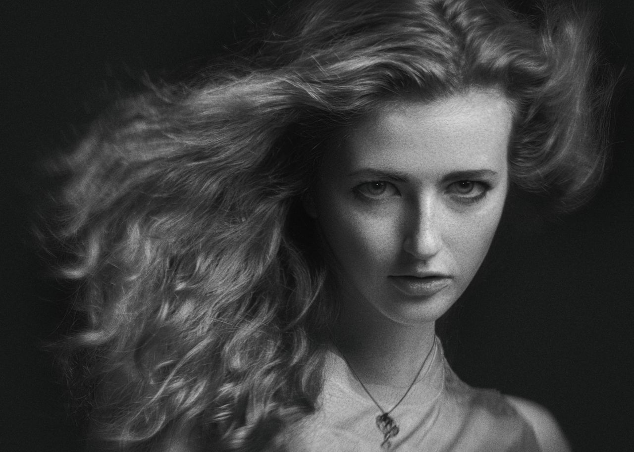 elegant grayscale portrait of a woman captured in a studio setting wit