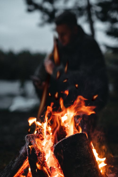 Silhouette of a Person Behind a Bonfire