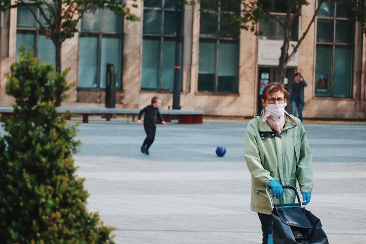 Anonymous Elderly Woman In Face Mask Walking Along Street After Shopping