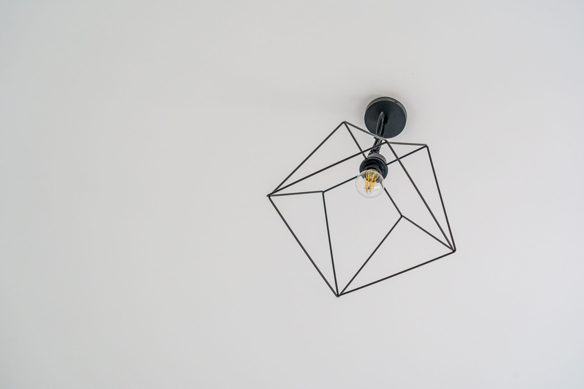 Stylish modern ceiling light fixture with a geometric design on a white background.