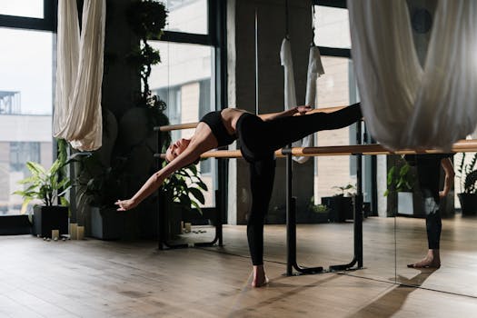 A woman stretches gracefully during a yoga session in a contemporary studio.