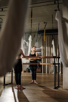 A young woman practices yoga in a modern studio, emphasizing wellness and fitness.
