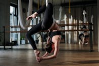 工作室里，一名女子正在练习空中瑜伽，展现出平衡性和灵活性