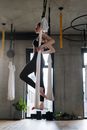 一名女子在室内练习空中瑜伽，展现力量与平衡