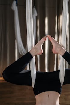 Focused yoga practice with silks emphasizing balance and flexibility indoors.