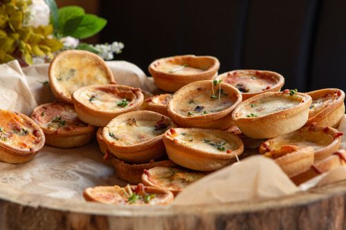 Free A close-up of freshly baked mini quiches, perfect for party appetizers. Stock Photo