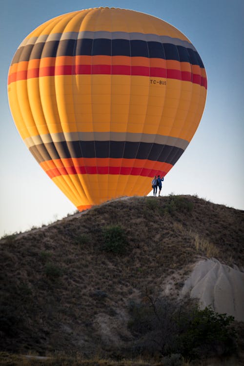 Colorful hot air balloon above hill